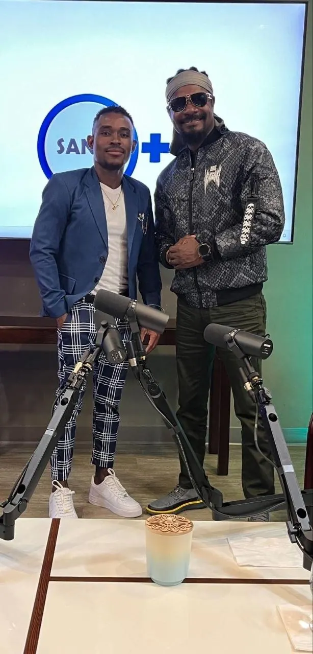 Two people beside microphones at an interview studio